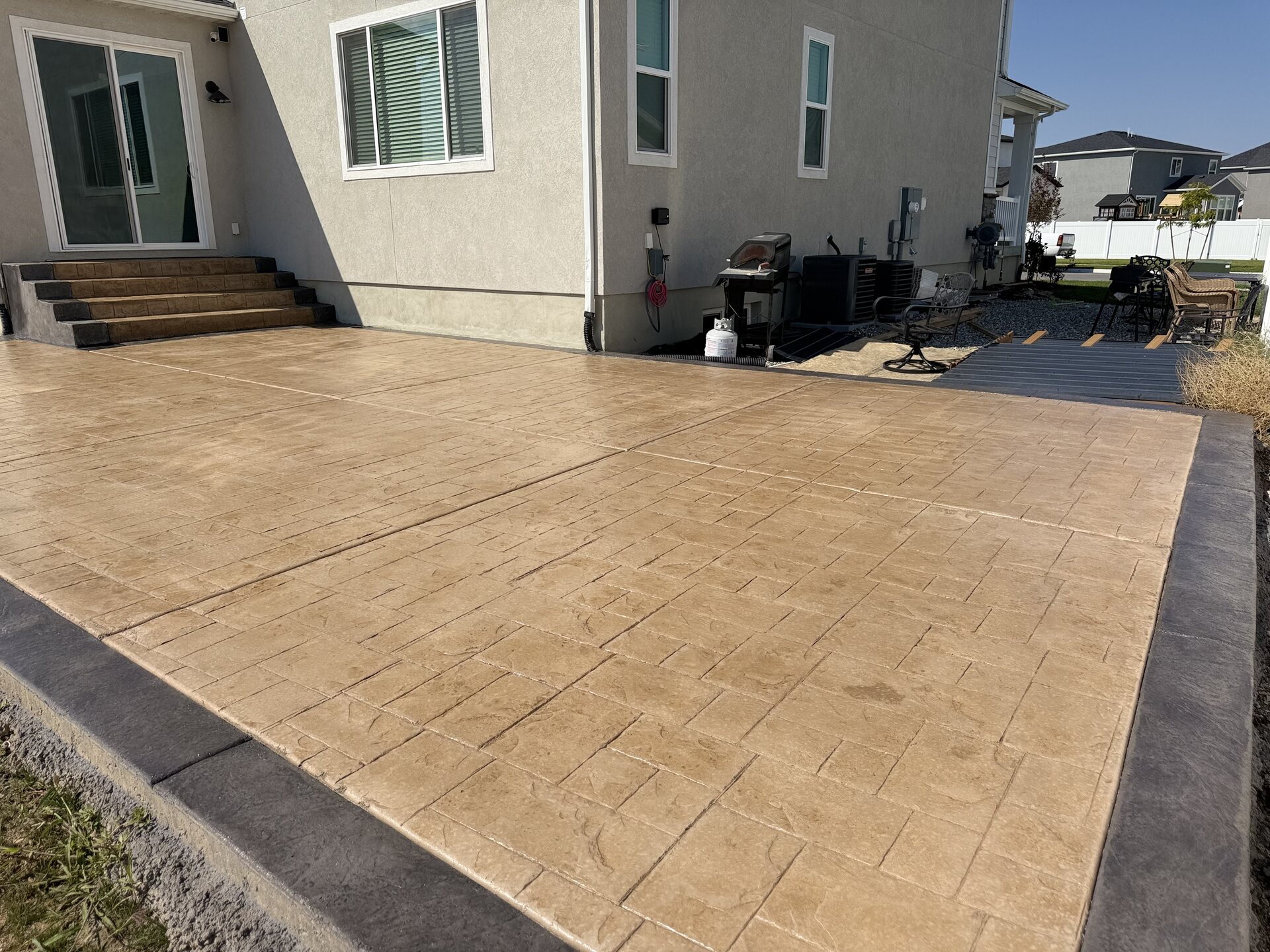 Tan colored concrete patio in a backyard