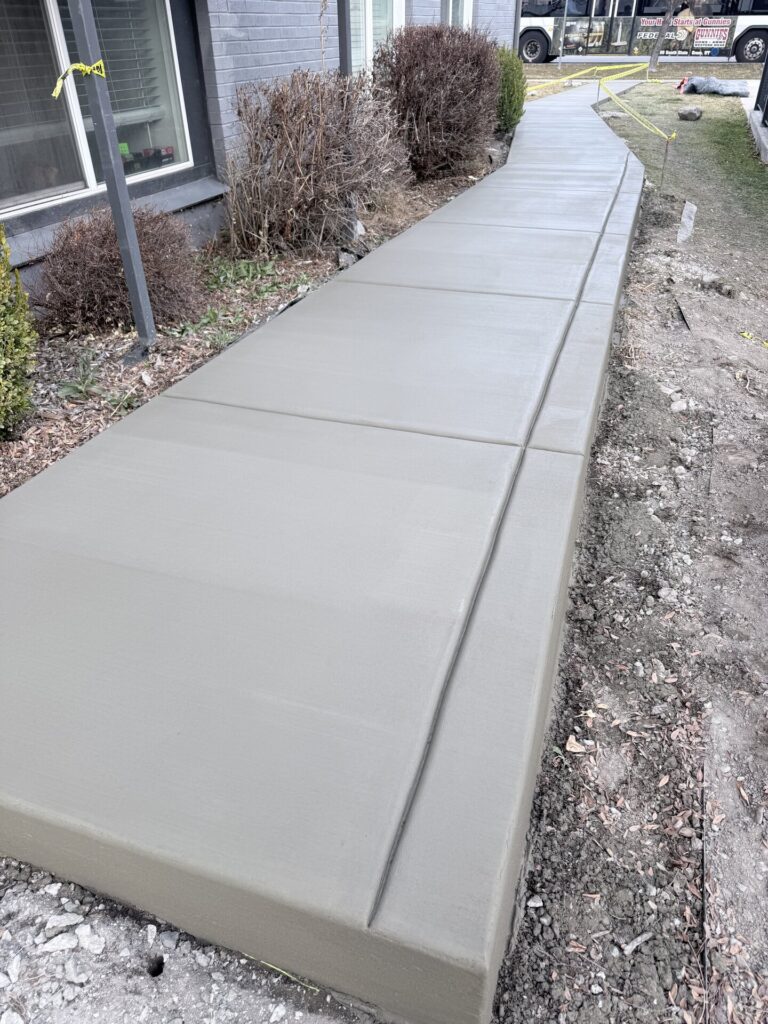 Long concrete walkway alongside a home