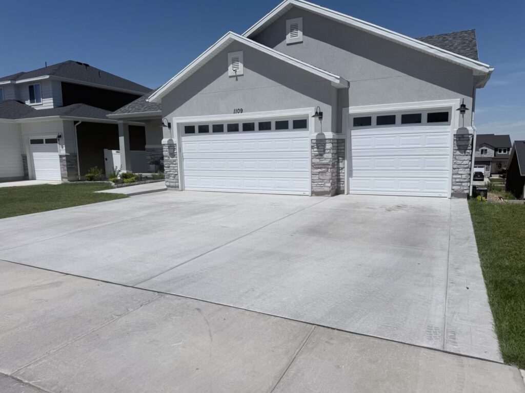 New concrete driveway with three-car garage at a Utah home